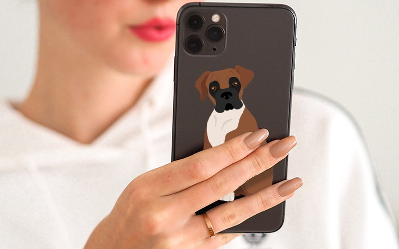 Woman holding phone with dog sticker on back