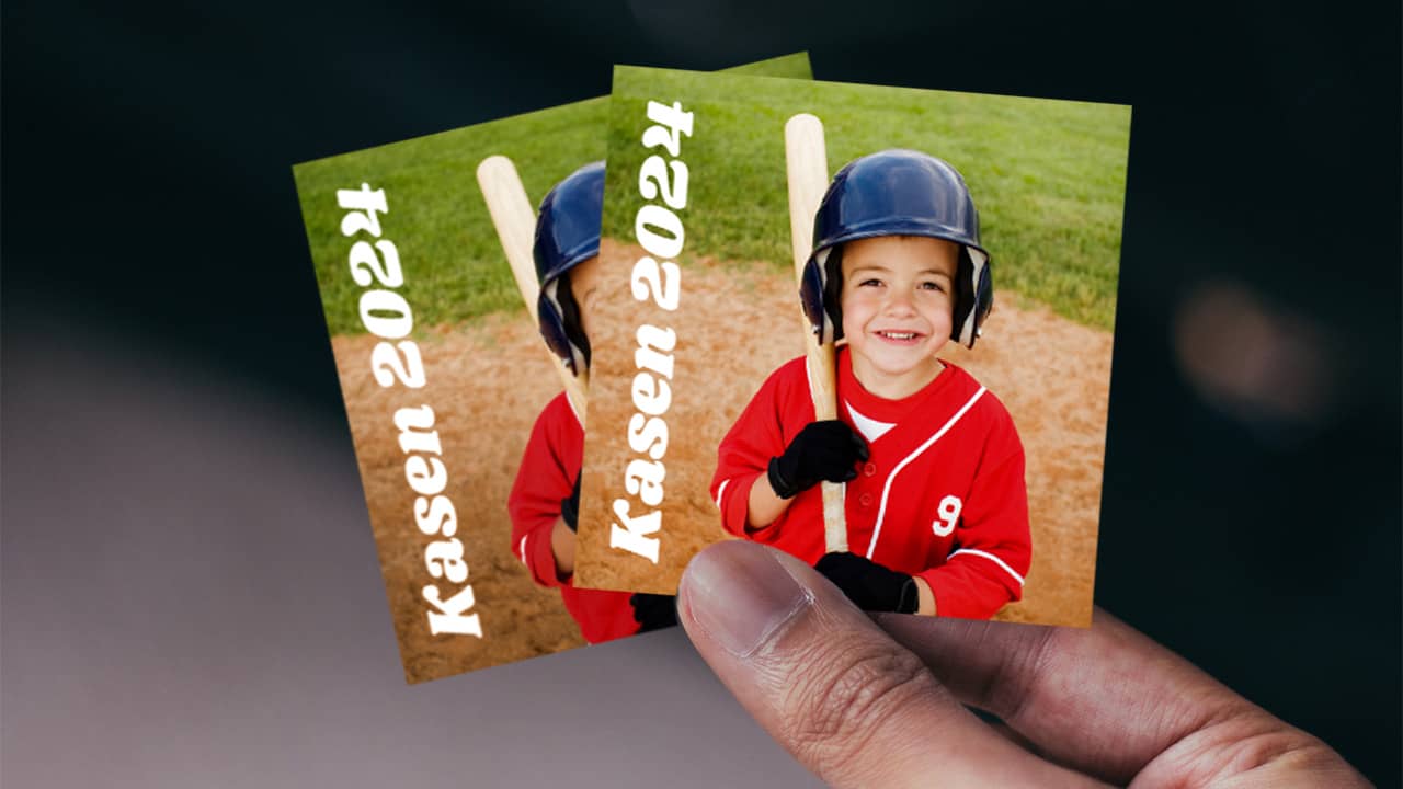 Hand holding stickers with child baseball photo