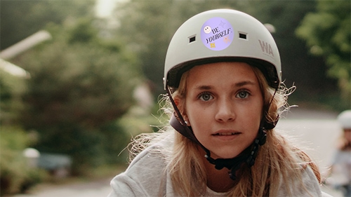 Girl wearing bike helmet with circle sticker on it