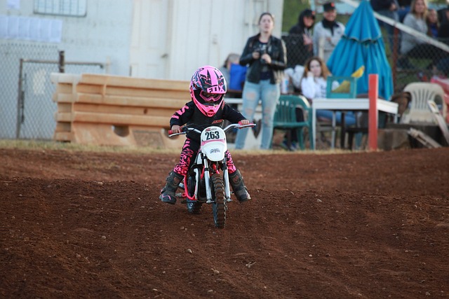 Little girl on dirt bike in pink helmet and jacket
