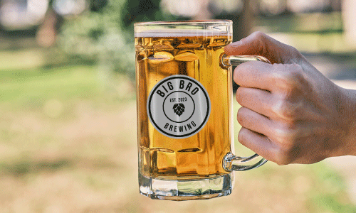Hand Holding Beer Stein with Brewery Sticker on it